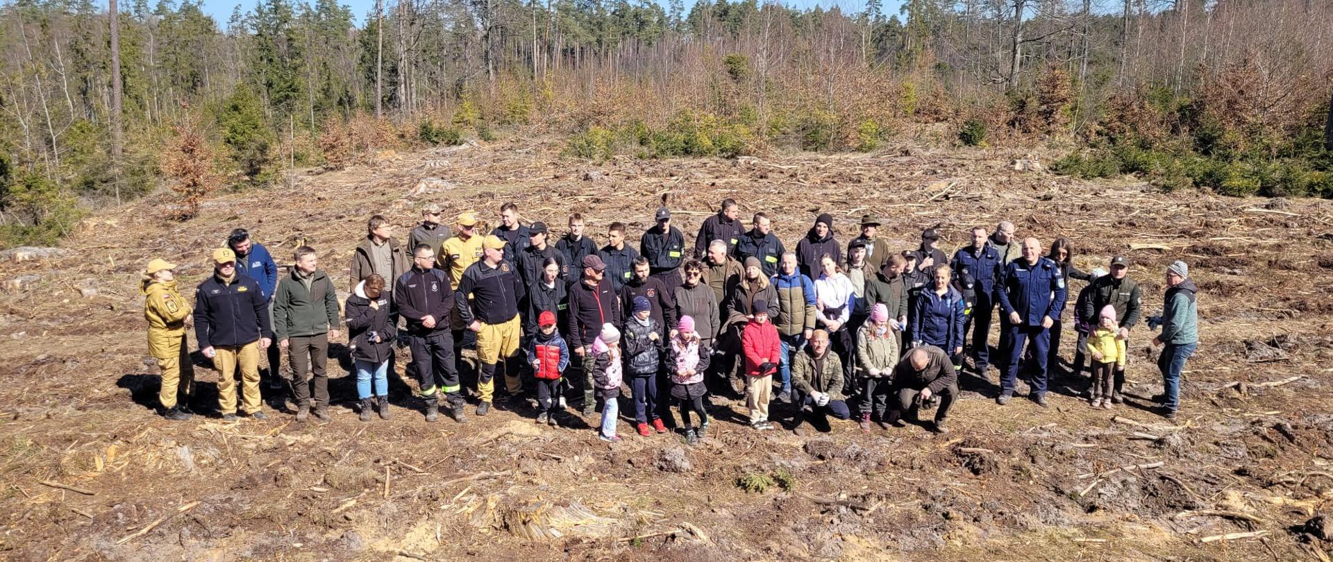 Zdjęcie grupowe wszystkich uczestników akcji. Uczestnicy stoją na polanie, w tle las.