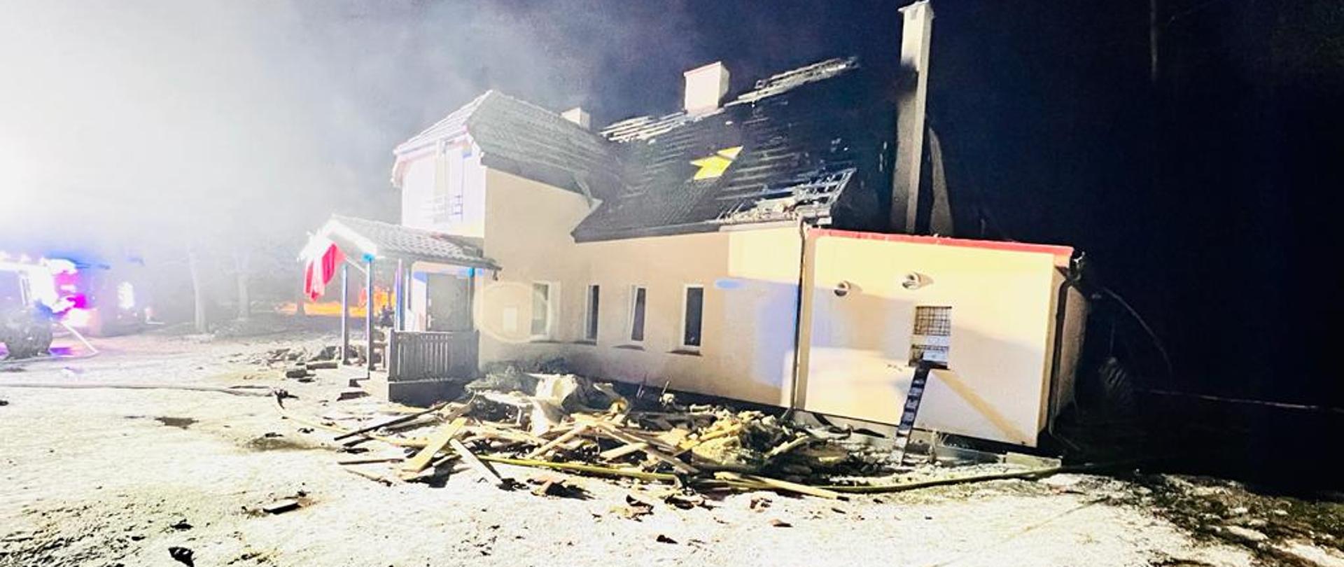 Zdjęcie przedstawia spalony budynek nocą po pożarze 