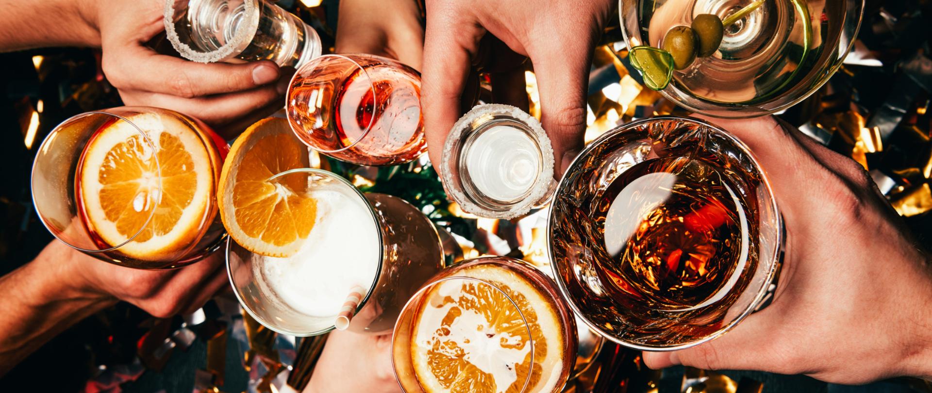 Na zdjęciu są drinki trzymane w dłoniach.