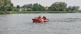 Na zdjęciu strażacy na łodzi ratowniczej na jeziorze, wyciągają osobę z wody podczas pokazu