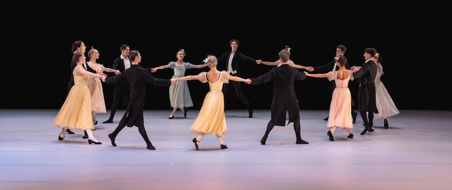 Zdjęcie przedstawiające uczniów szkoły, którzy w czasie koncertu szkolnego tańczą poloneza.