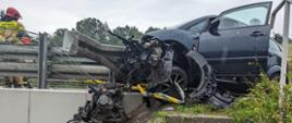 Rozbity samochód osobowy oraz strażak