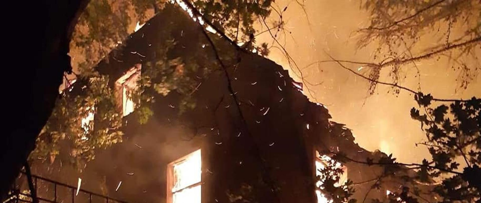 Zdjęcie przedstawia płonący pałac. Budnynek bez dachu, płomienie wewnątrz.