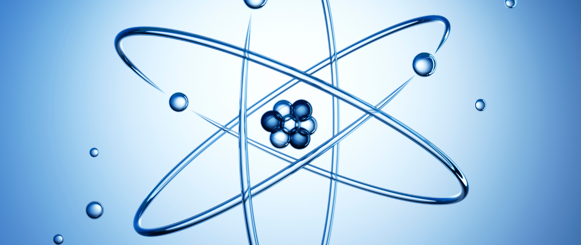 Na niebieskim tle wizualizacja jadra atomowego z elektronami ( rozrzucone niebieskie małe kulki).