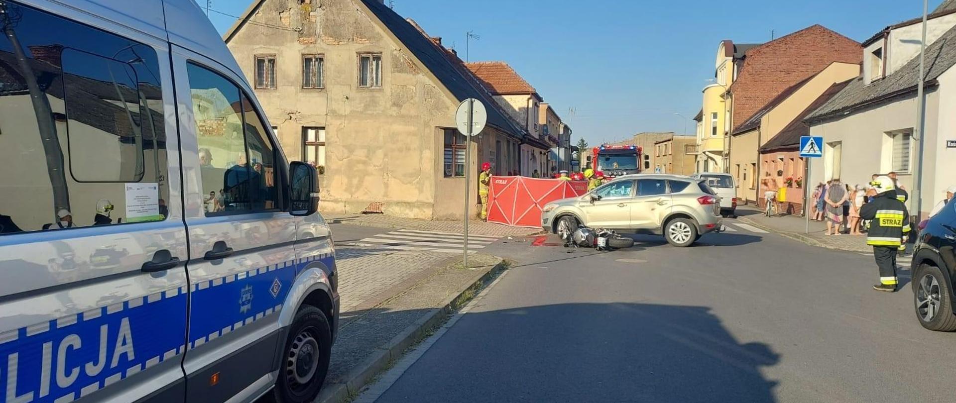 Motocykl po zderzeniu z samochodem osobowym oraz działające służby