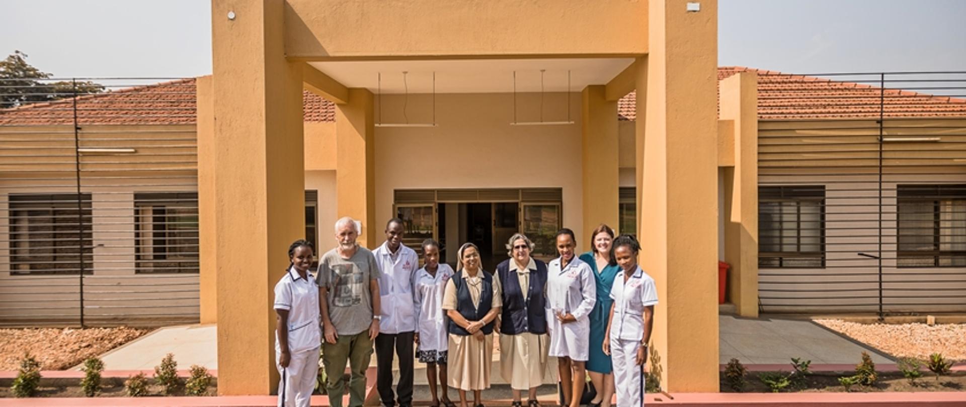 Personel medyczny i inne osoby zaangażowane w budowę szpitala przed budynkiem 