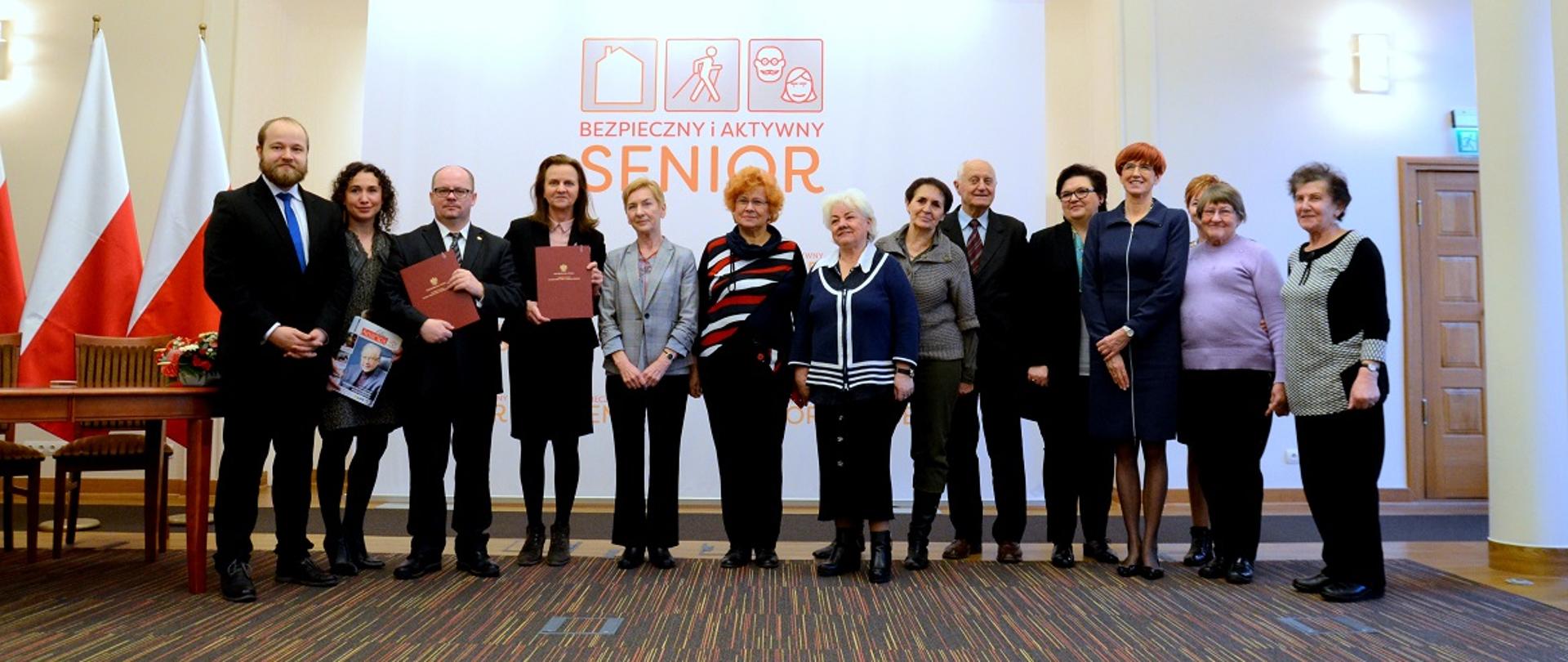 Podpisanie porozumienia w ramach kampanii ministerstwa rodziny "Bezpieczny i aktywny senior". Wspólne zdjęcie minister rodziny Elżbiety Rafalskiej z uczestnikami wydarzenia: seniorami, prezes ZUS Gertrudą Uścińską, wiceminister rodziny Elżbietą Bojanowską.