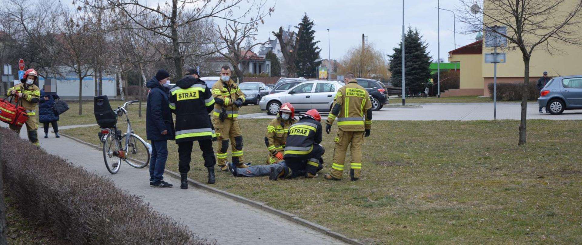 udzielanie kwalifikowanej pierwszej pomocy przez strażaków osobie leżącej na ziemi
