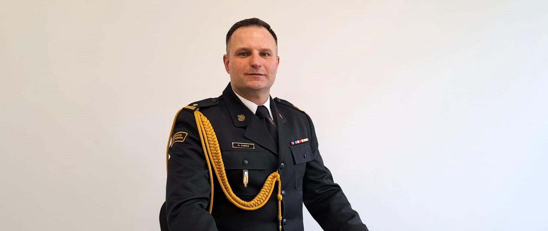 na zdjęciu mł. bryg. Rafał Zadka - Zastępca Komendanta Powiatowego PSP w Oleśnicy w pozycji siedzącej w umundurowaniu galowym