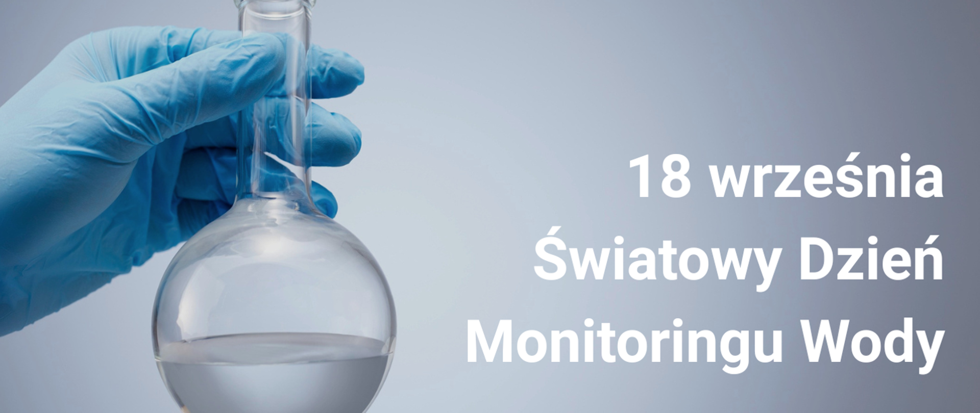 Dłoń w niebieskiej rękawiczce trzyma laboratoryjną kolbę z wodą. Po prawej stronie widnieje napis: „18 września – Światowy Dzień Monitoringu Wody”.