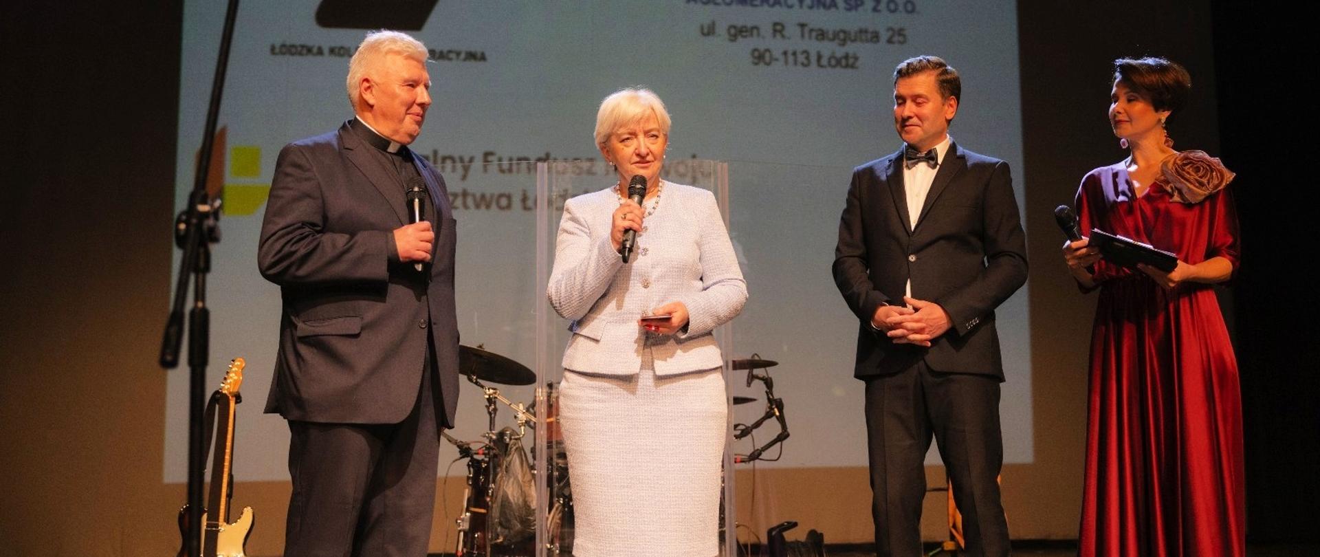 Wojewoda łódzki Dorota Ryl wręcza medal Gloria Artis ks. Piotrowi Turkowi