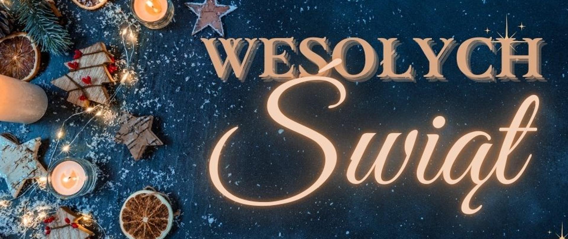 Grafika w motywach świątecznych, ze świecą, pierniczkami i płatkami śniegu. Na granatowym tle znajduje się duży napis: "Wesołych Świąt".