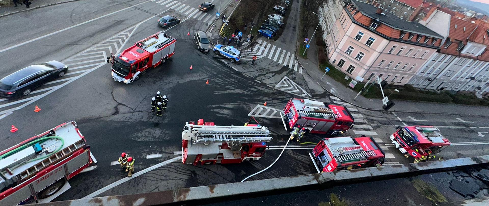 Na zdjęciu widać pojazdy strażackie, stojące na drodze