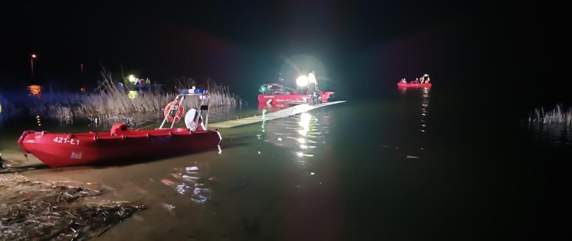 Jest pora nocna. Na zdjęciu widać cztery łodzie motorowe biorące udział w odnalezieniu poszkodowanego, który najprawdopodobniej nie dopłynął do brzegu