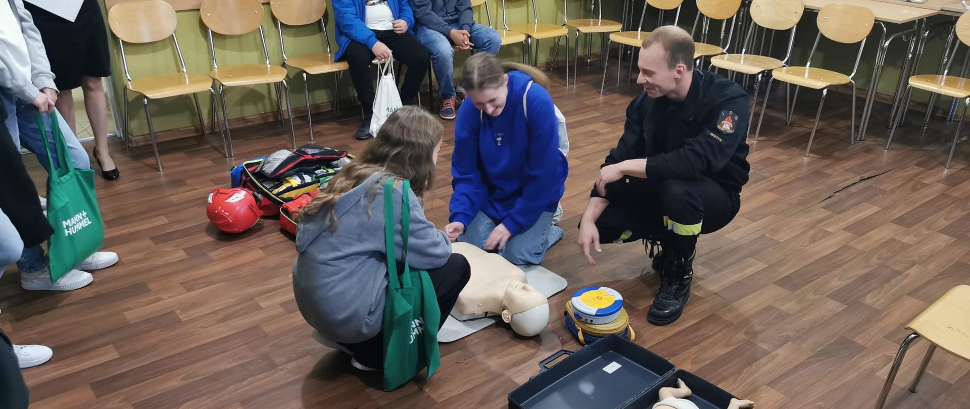 Strażacy pokazują na fantomach jak udzielać pierwszej pomocy.