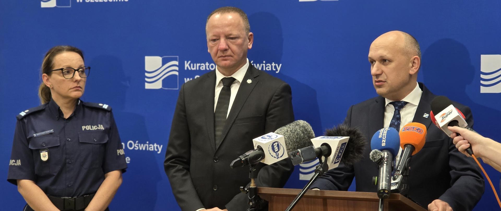Zachodniopomorski Kurator Oświaty Paweł Palczyński, wypowiada się podczas konferencji prasowej, po jego prawej stronie stoi Zastępca Komendanta Wojewódzkiego Policji w Szczecinie dr Marek Jasztal oraz Naczelnik Wydziału Prewencji KWP w Szczecinie Monika Mocianko-Pawlak 