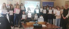 grupa młodzieży z dyplomami Młodzieżowy Lider Zdrowia - kontra HIV, z prawej strony grupy prelegentka 