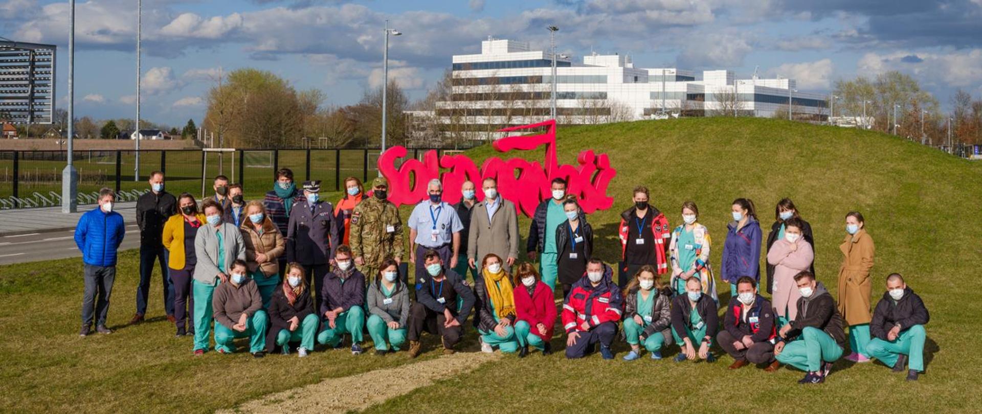 Zespół medyczny na tle logo Solidarności 