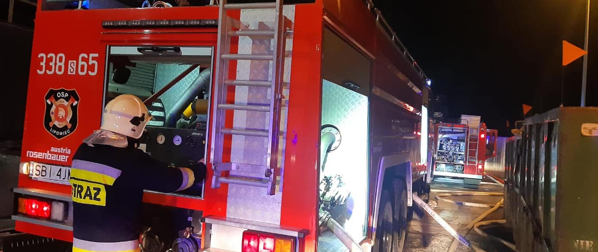 Zdjęcie przedstawia strażaka przy autopompie. 