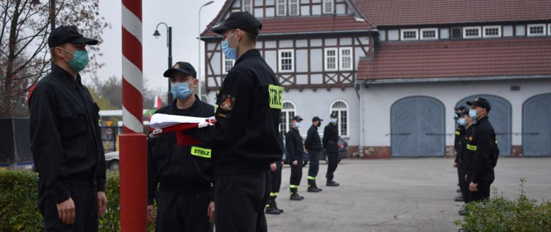 Zdjęcie przedstawia uroczyste podniesienie flagi państwowej na terenie Komendy Miejskiej Państwowej Straży Pożarnej w Zabrzu z okazji Narodowego Święta Niepodległości przez zabrzańskich strażaków
