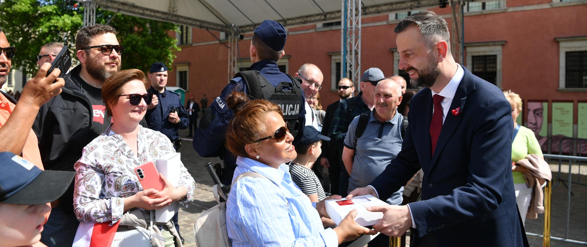 Dzień Flagi. Uroczystości na placu zamkowym. Szef MON wręcza flagę uczestnikom uroczystości