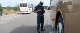 Szczegółowa kontrola stanu technicznego autokaru z użyciem Mobilnej Jednostki Diagnostycznej. Inspektor kujawsko-pomorskiej Inspekcji Transportu Drogowego sprawdza siłę hamowania kół pierwszej osi zatrzymanego autobusu wycieczkowego.