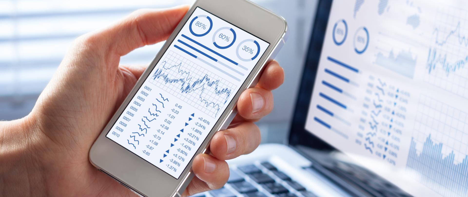 Investor analyzing stock market investments with financial dashboard, business intelligence (BI), and key performance indicators (KPI) on smartphone and computer screens