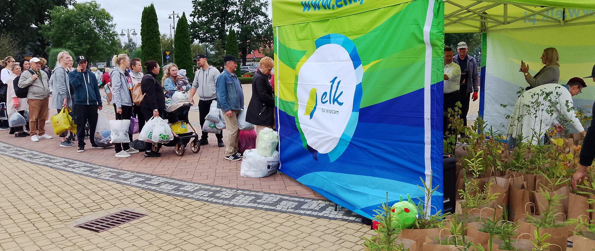 kolejka ludzi do stoiska z roślinami