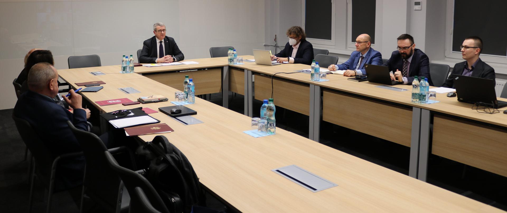 Posiedzenie Zespołu do spraw rozwiązań dotyczących wynagrodzeń na uczelniach publicznych z udziałem wiceministra Wojciecha Murdzka, wiceminister Wojciech Murdzek siedzi przy stole z innymi uczestnikami posiedzenia.
