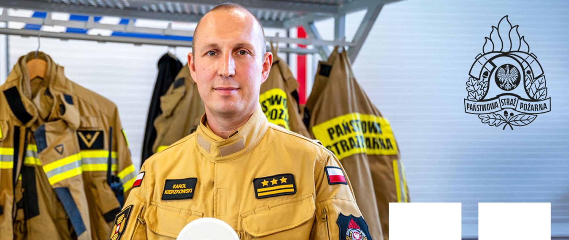 Strażak trzymający w rękach czujkę dymu