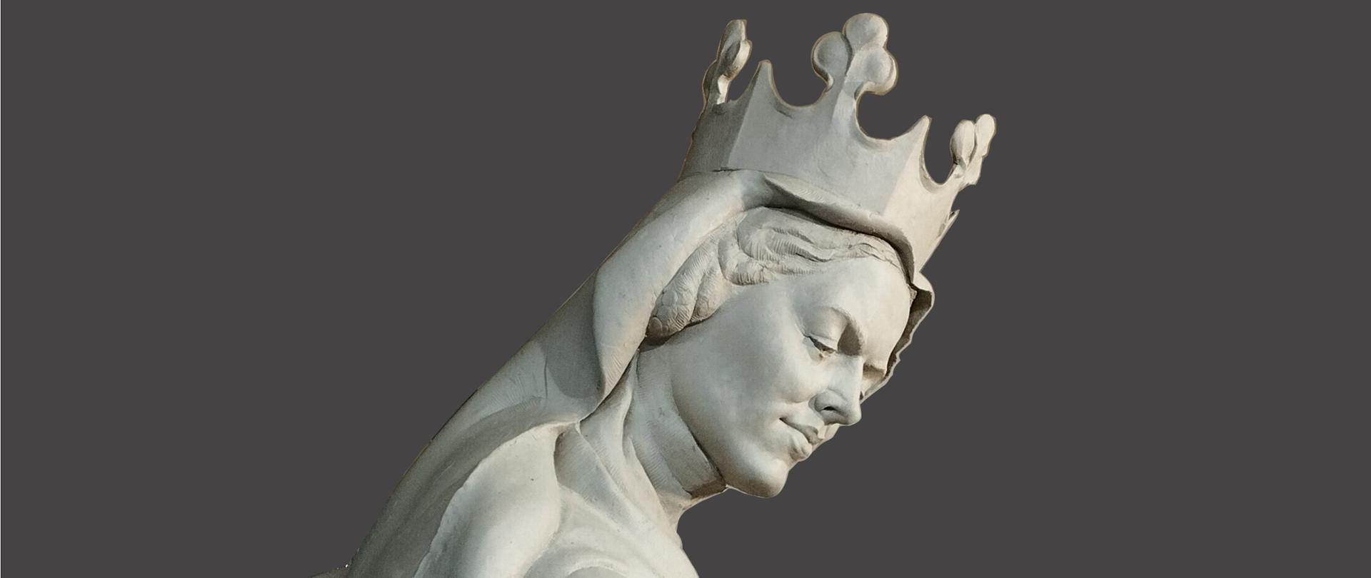 Na zdjęciu w centralnej części przedstawiona jest rzeźba - postać Królowej Ryksy Elżbiety. Rzeźba wykonany jest z szarej gliny. Postać królowej pokazana jest z boku. Królowa ma na głowie koronę, ma długie rozpuszczone włosy. Postać ma na głowie welon, ubrana jest w długą suknię. 
