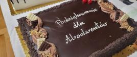 Zdjęcie przedstawiające tort czekoladowy podany z okazji koncertu absolwentów.