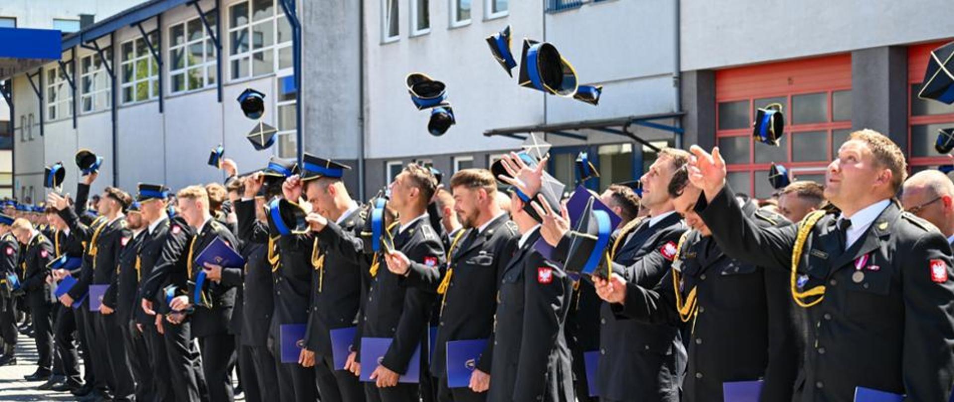 Strażacy podrzucają rogatywki w górę 
