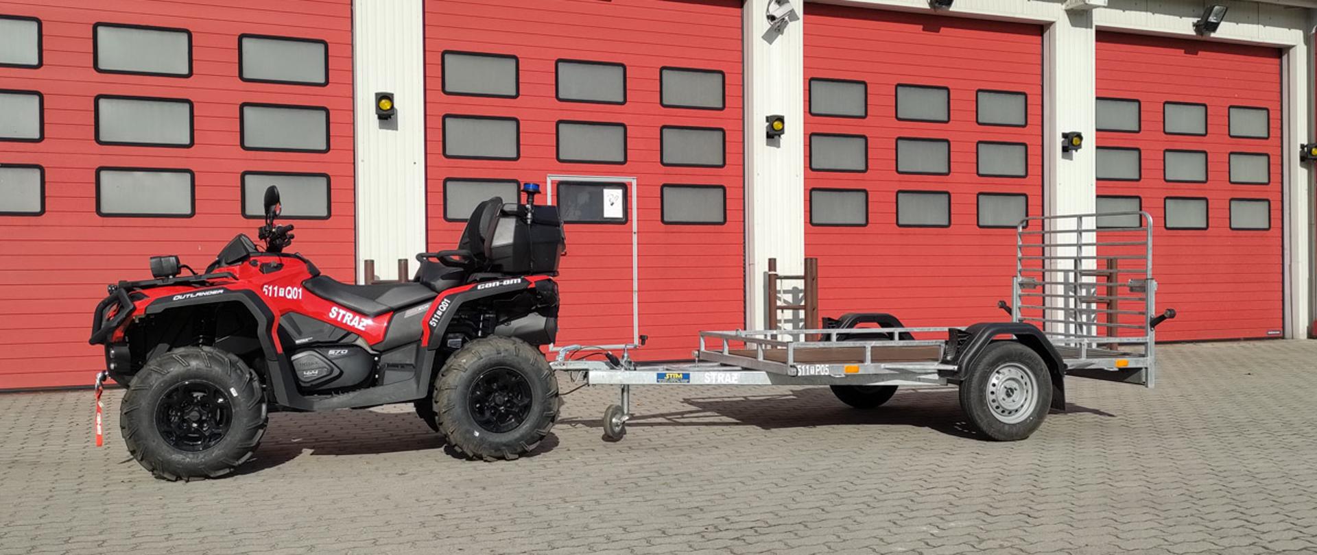 Pojazd terenowy, quad koloru czerwonego i numerze operacyjnym 511-Q01, do niego podczepiona została przyczepka lekka do jego przewozu