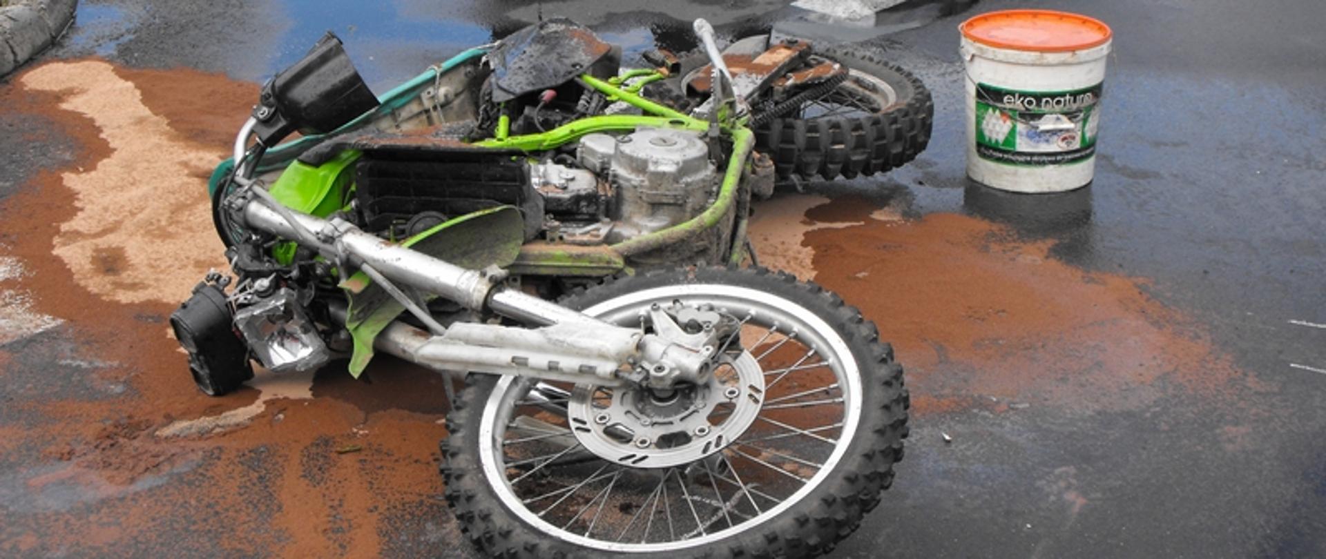 Zdjęcie przedstawia rozbity motocykl na drodze