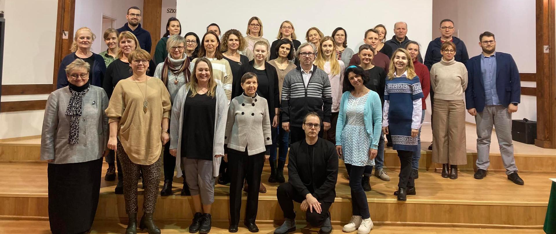 Uczestnicy warsztatów razem z prowadzącym stoją na scenie PSM w Koninie