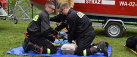 Strażacy pokazują z wykorzystaniem fantoma jak udzielają pierwszej pomocy.