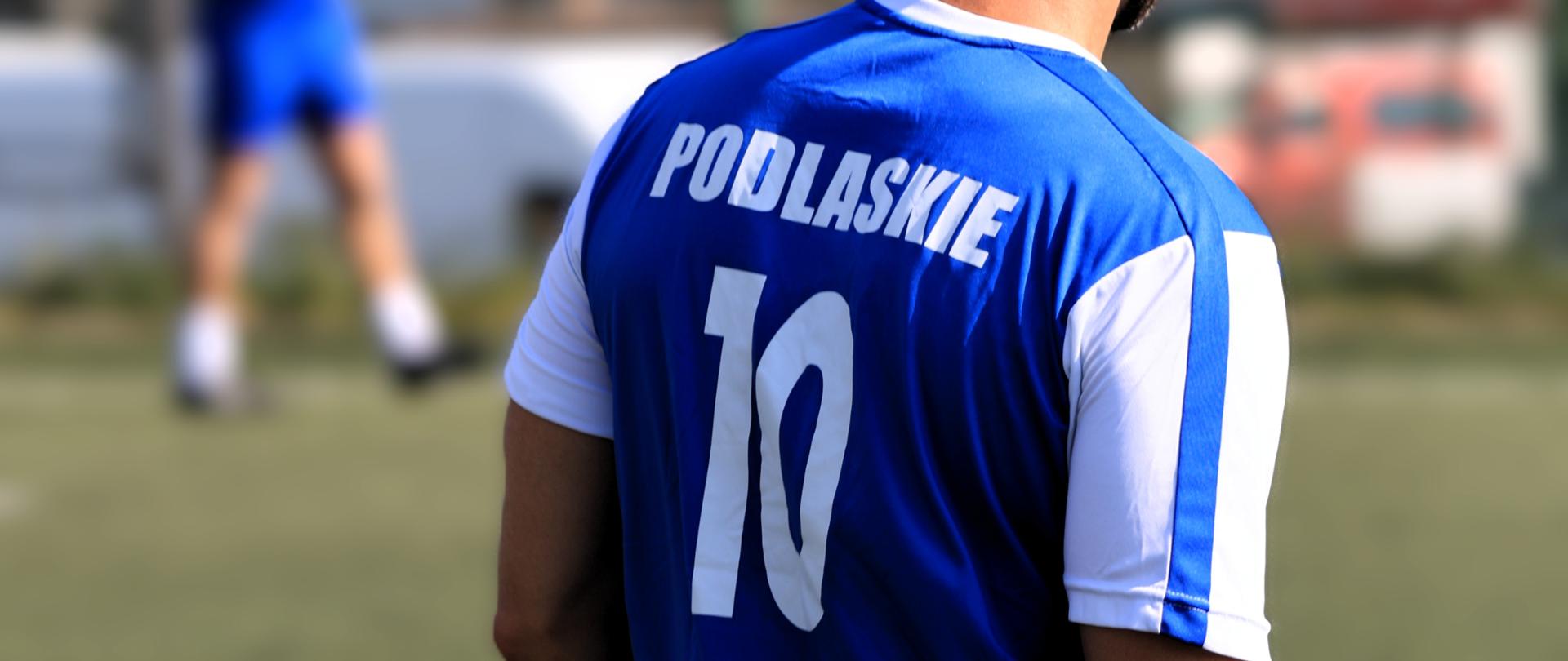 Podlascy strażacy przygotowują się do IV Mistrzostw Polski Strażaków w Piłce Nożnej 6-cio osobowej - reprezentant Podlasia w klubowej koszulce odwrócony plecami - na koszulce widnieje napis "Podlaskie 10"