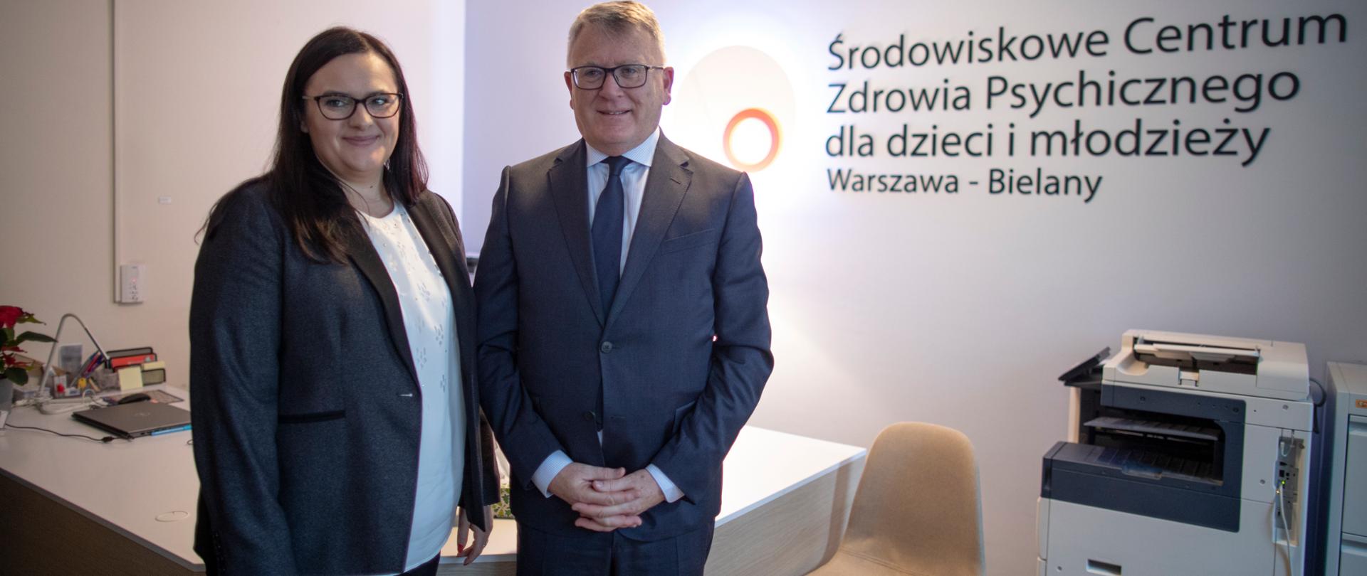 Na tle recepcji stoją obok siebie Małgorzata Jarosińska-Jedynak oraz Nicolas Schmit