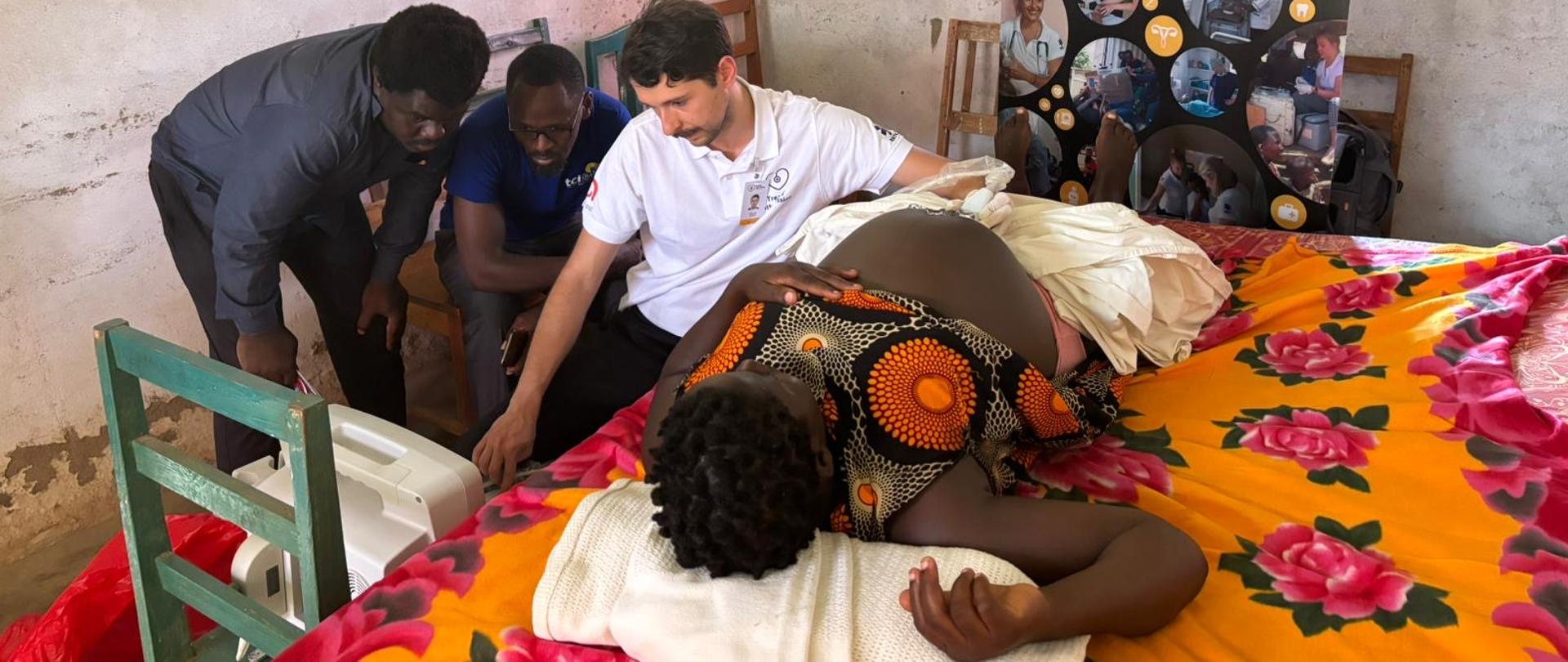 Lekarz wykonuje badanie usg przez brzuch ciężarnej kobiety, dwóch innych mężczyzn obserwuje monitor