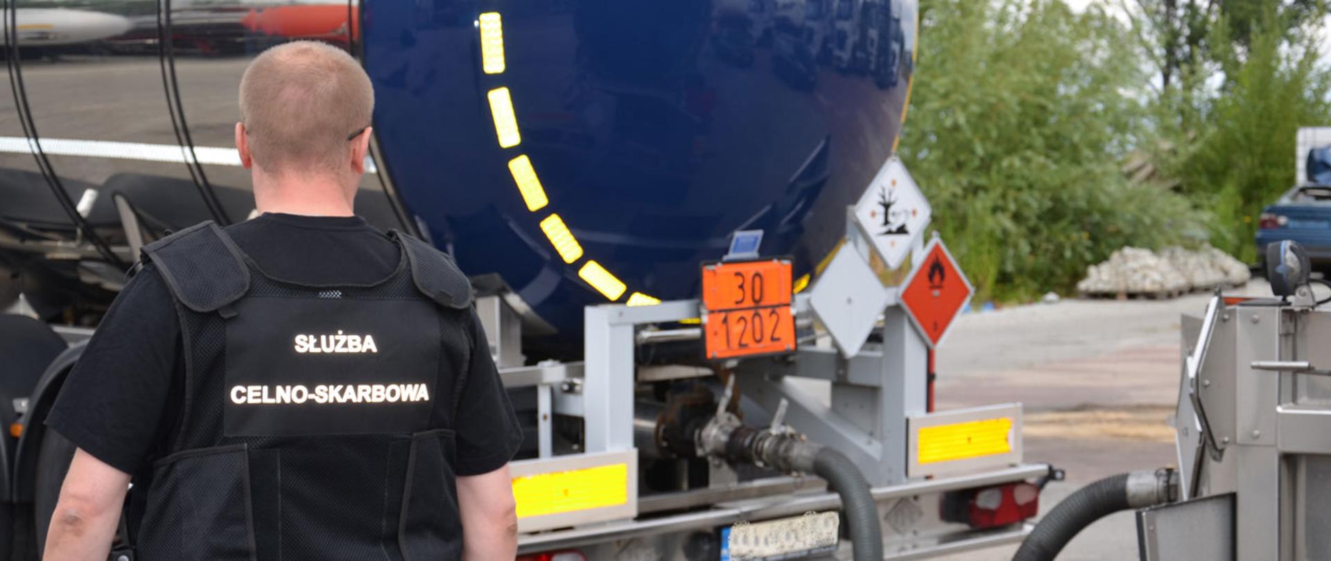 Funkcjonariusz Służby Celno-Skarbowej przy cysternie.
