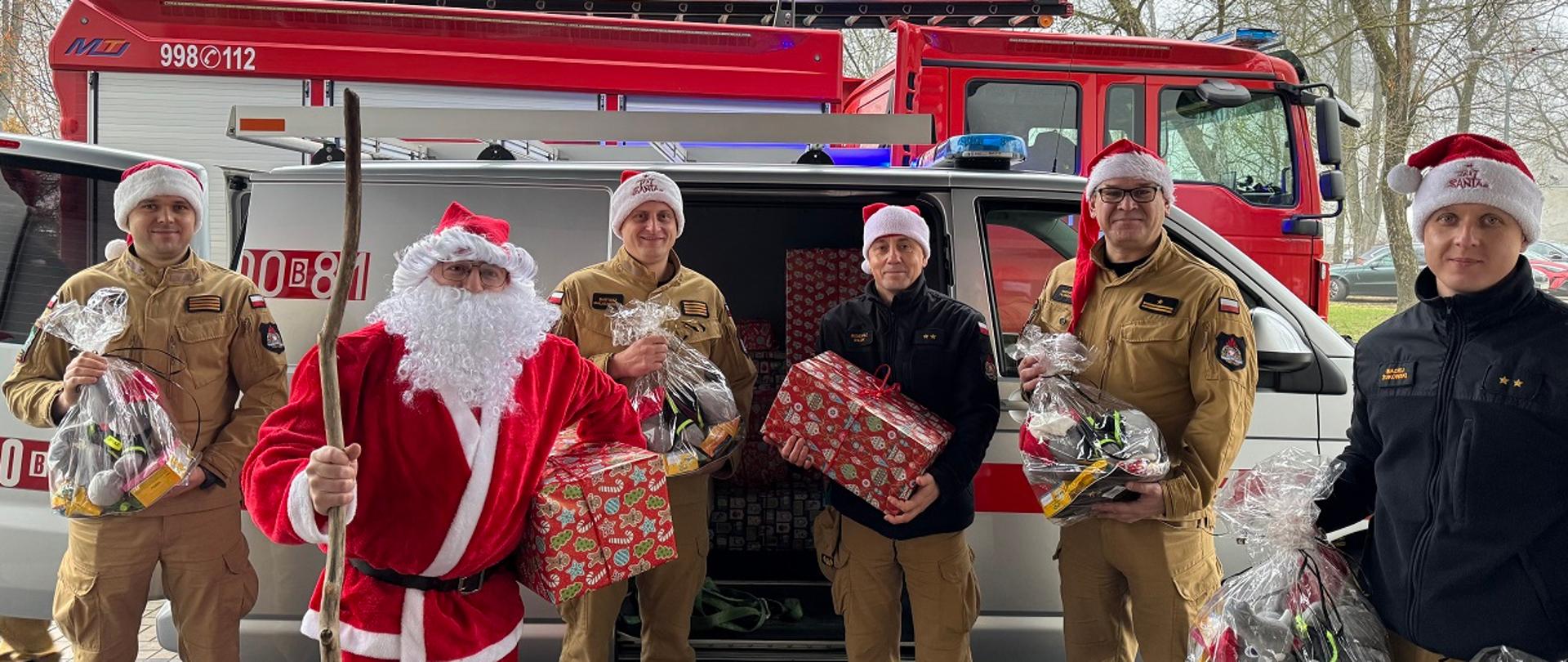 Strażacki Mikołaj ze swoimi pomocnikami i z prezentami 