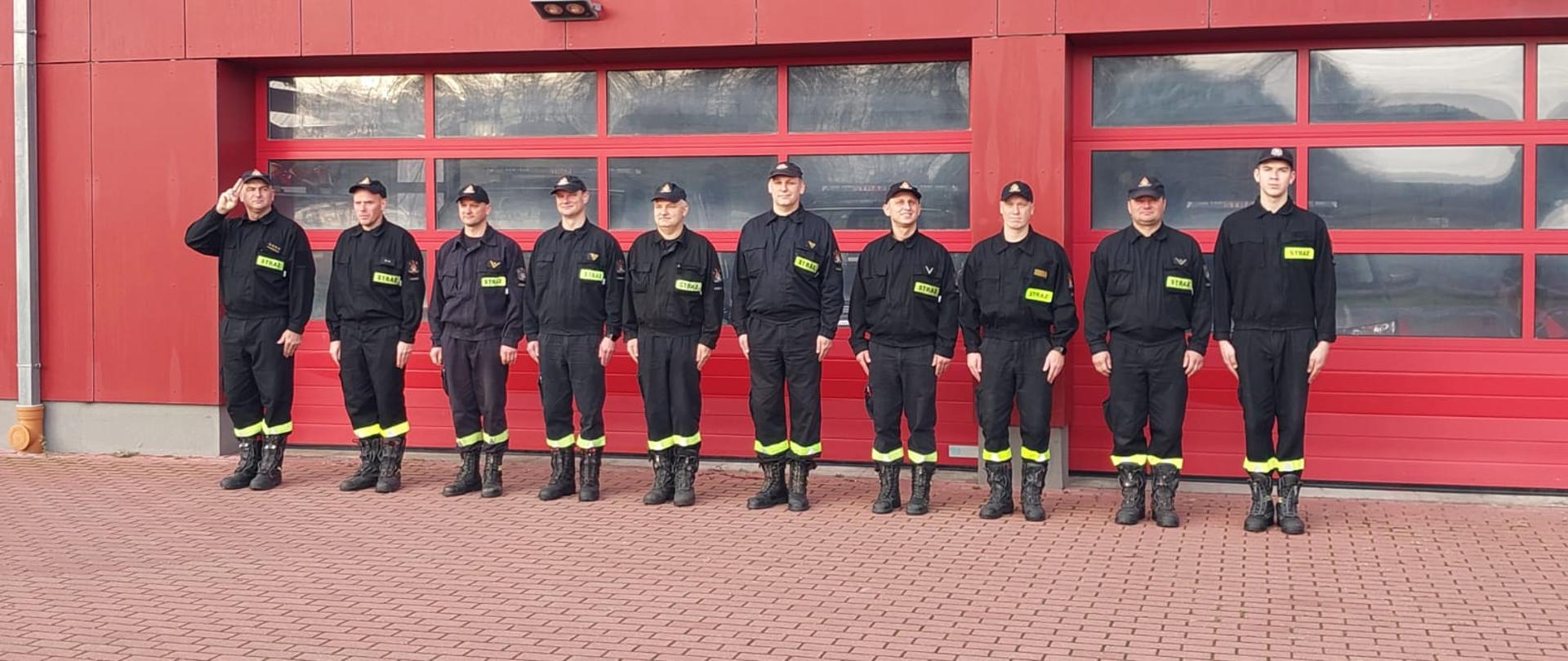 Ratownicy z Komendy Powiatowej PSP na placu przed budynkiem komendy odśpiewują narodowy hymn