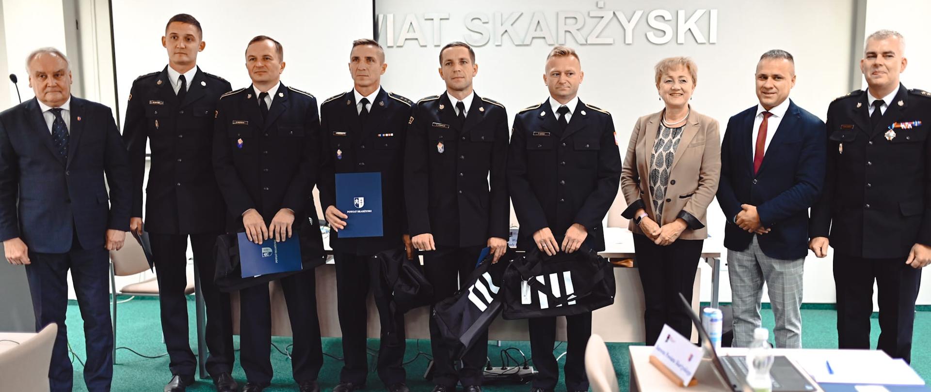 Strażacy nagrodzeni przez starostwo powiatowe w Skarżysku-kamiennej pozują do zdjęcia ze swoim szefem, starostą i radnymi.