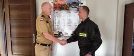 Na zdjęciu Zastępca Komendanta Powiatowego PSP w Rypinie kpt. Marcin Czarnecki wręcza akt mianowania na stanowisko stażysty w służbie przygotowawczej str. Dawidowi Bartnickiemu. 