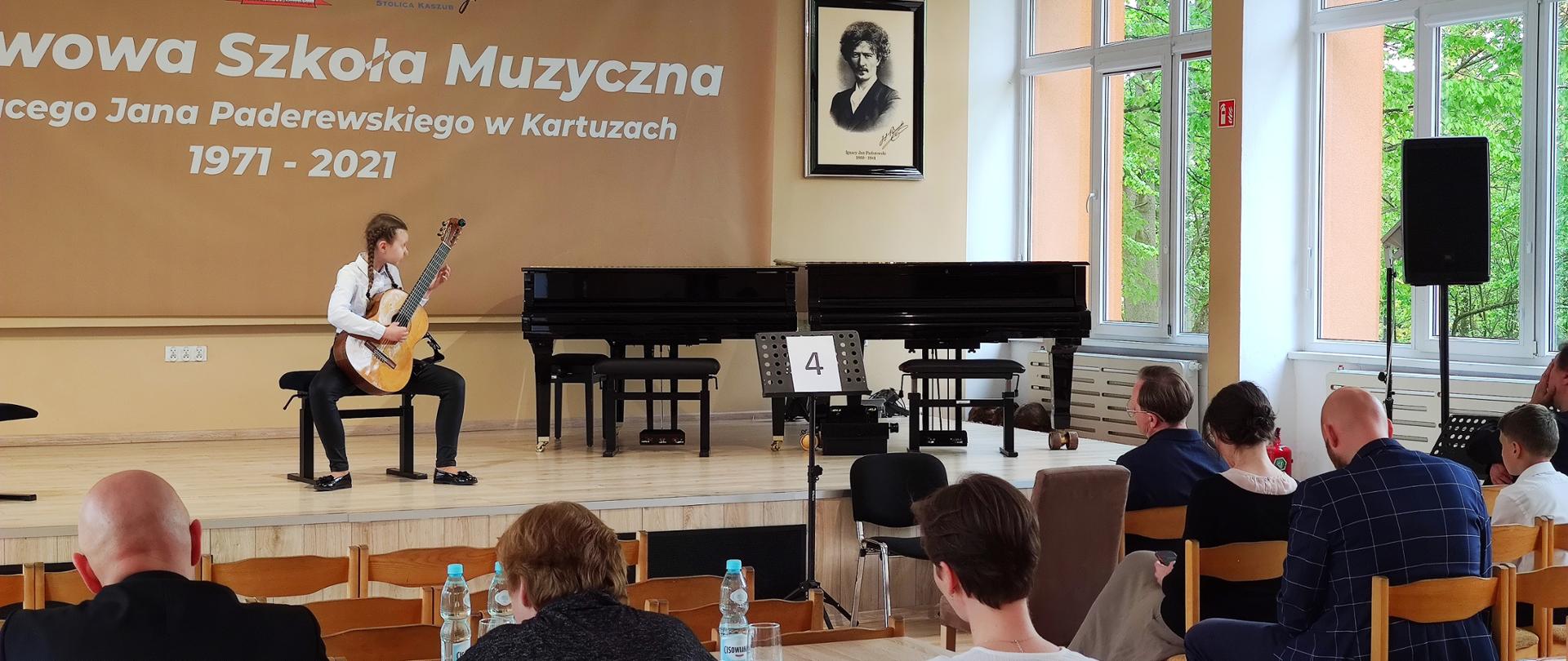 na scenie gra uczestniczka konkursu młodego gitarzysty, na widowni widać słuchaczy