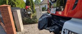 Na pierwszym planie samochód gaśniczy przed posesją gdzie doszło do zdarzenia