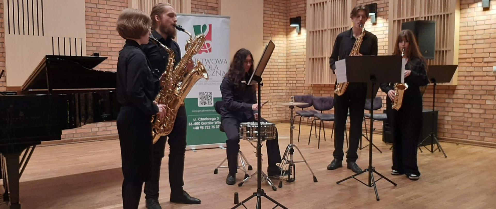 Czworo uczniów z saksofonami. Między nimi perkusista z werblem