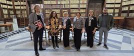 Group photo in the National Library of Malta in front of bookshelves.