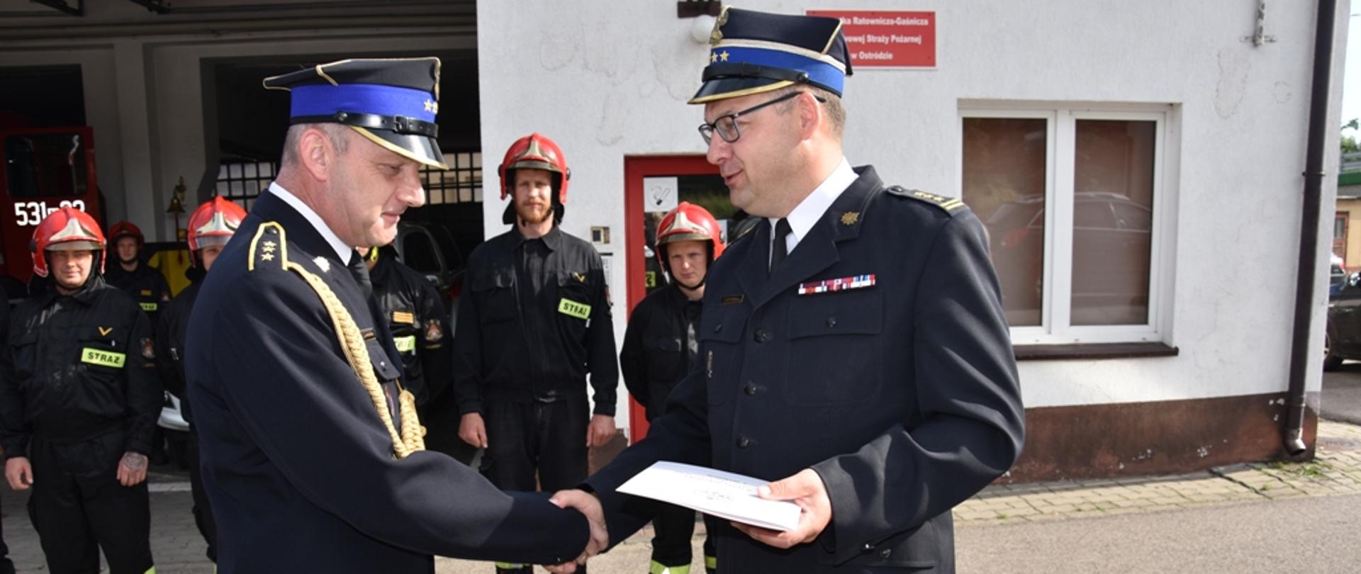 Komendant Powiatowy PSP st. bryg. Tomasz Ostrowski wręczający asp. sztab. Januszowi Markowskiemu decyzję o zwolnieniu ze służby w PSP 